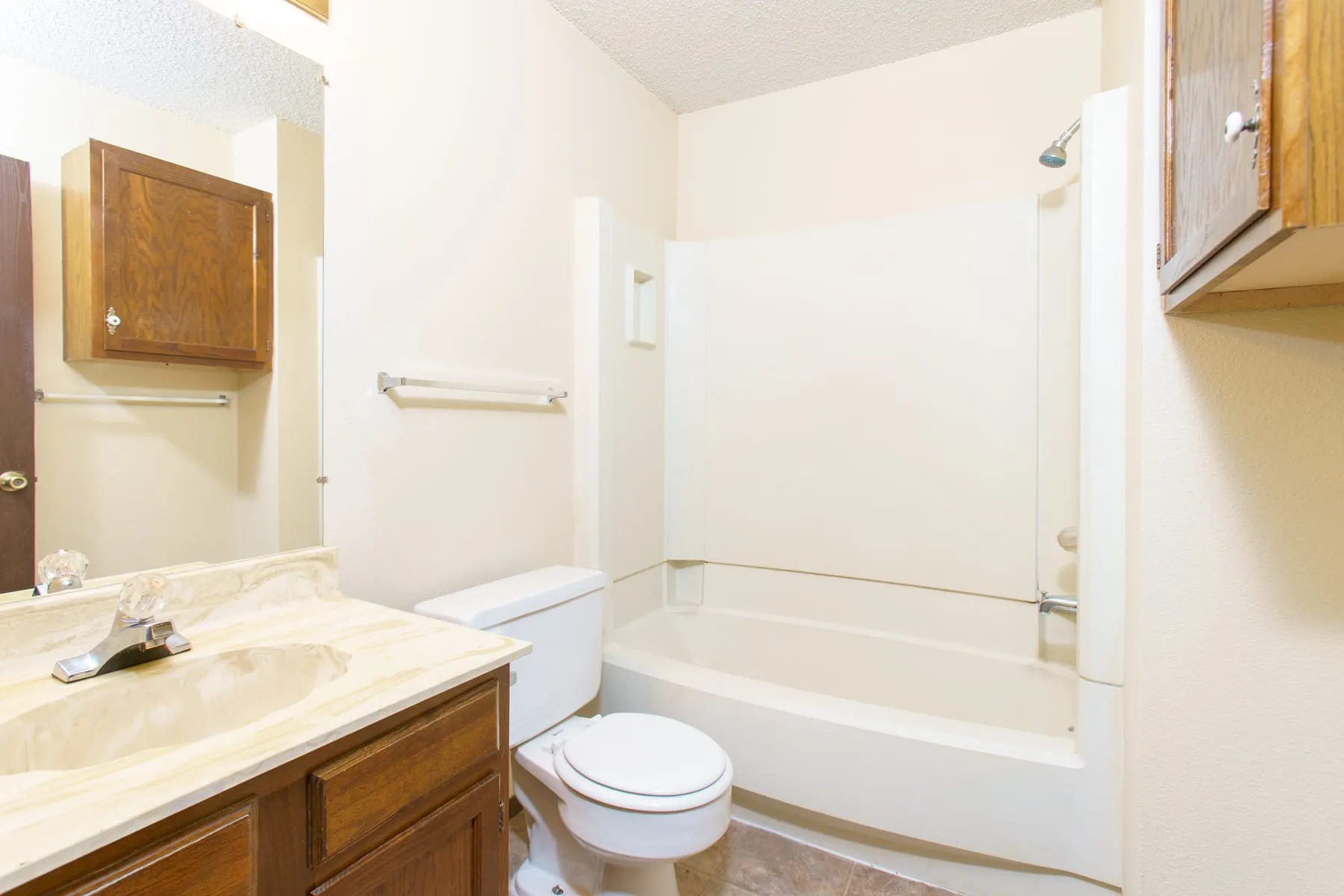 Original one bedroom bathroom with oak vanity and tub.
