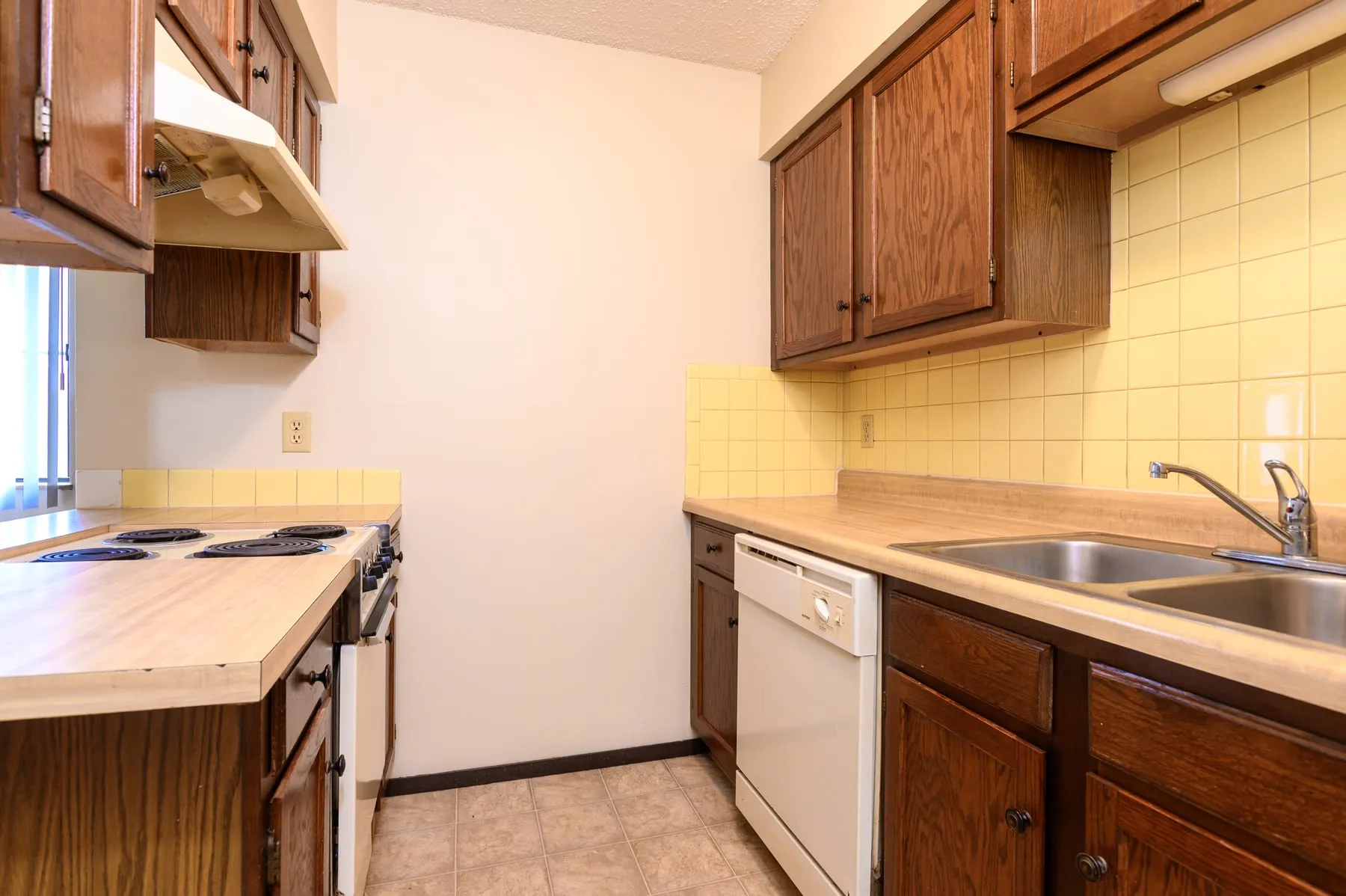 Original studio kitchen with oak cabinetry and laminate counters.