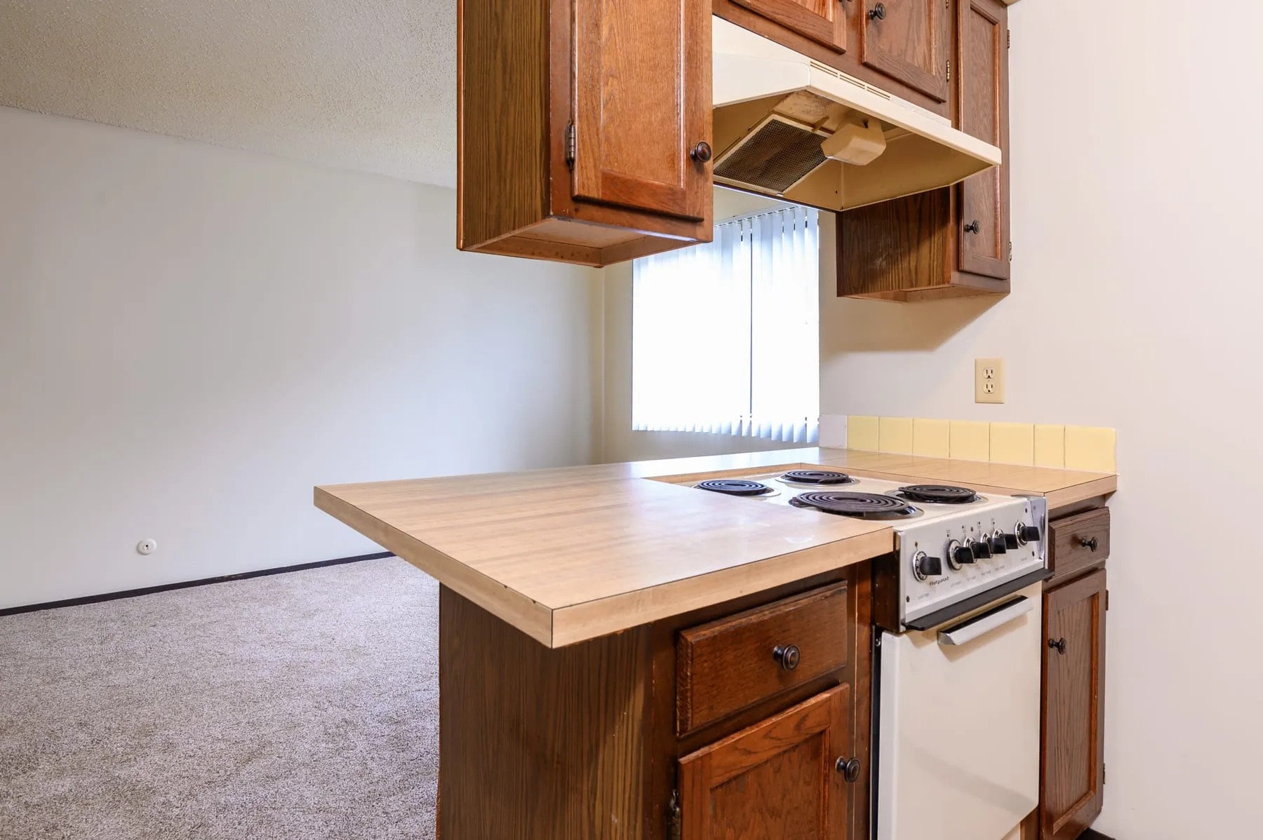 Original studio kitchen peninsula with laminate counters and a range.
