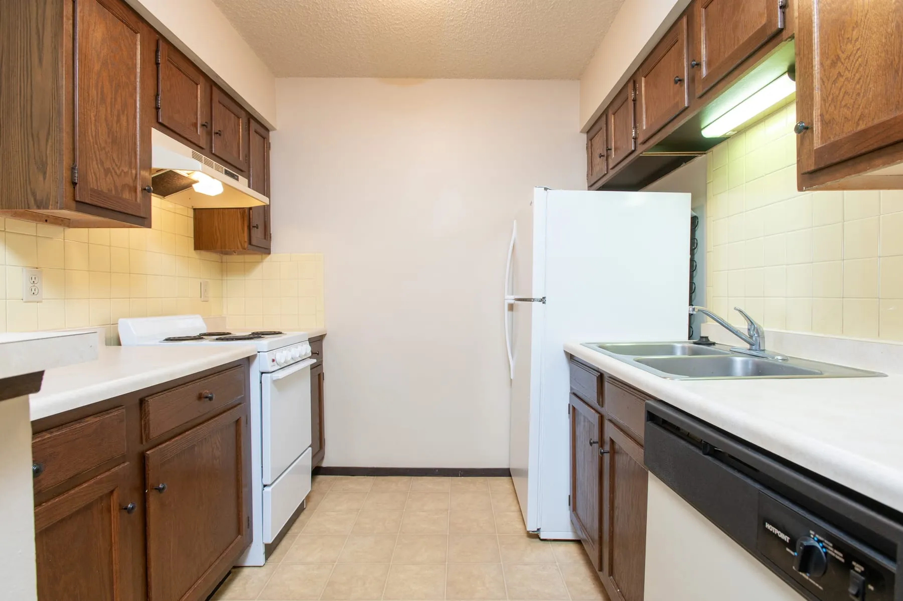 Original two bedroom kitchen with oak cabinetry and laminate counters.