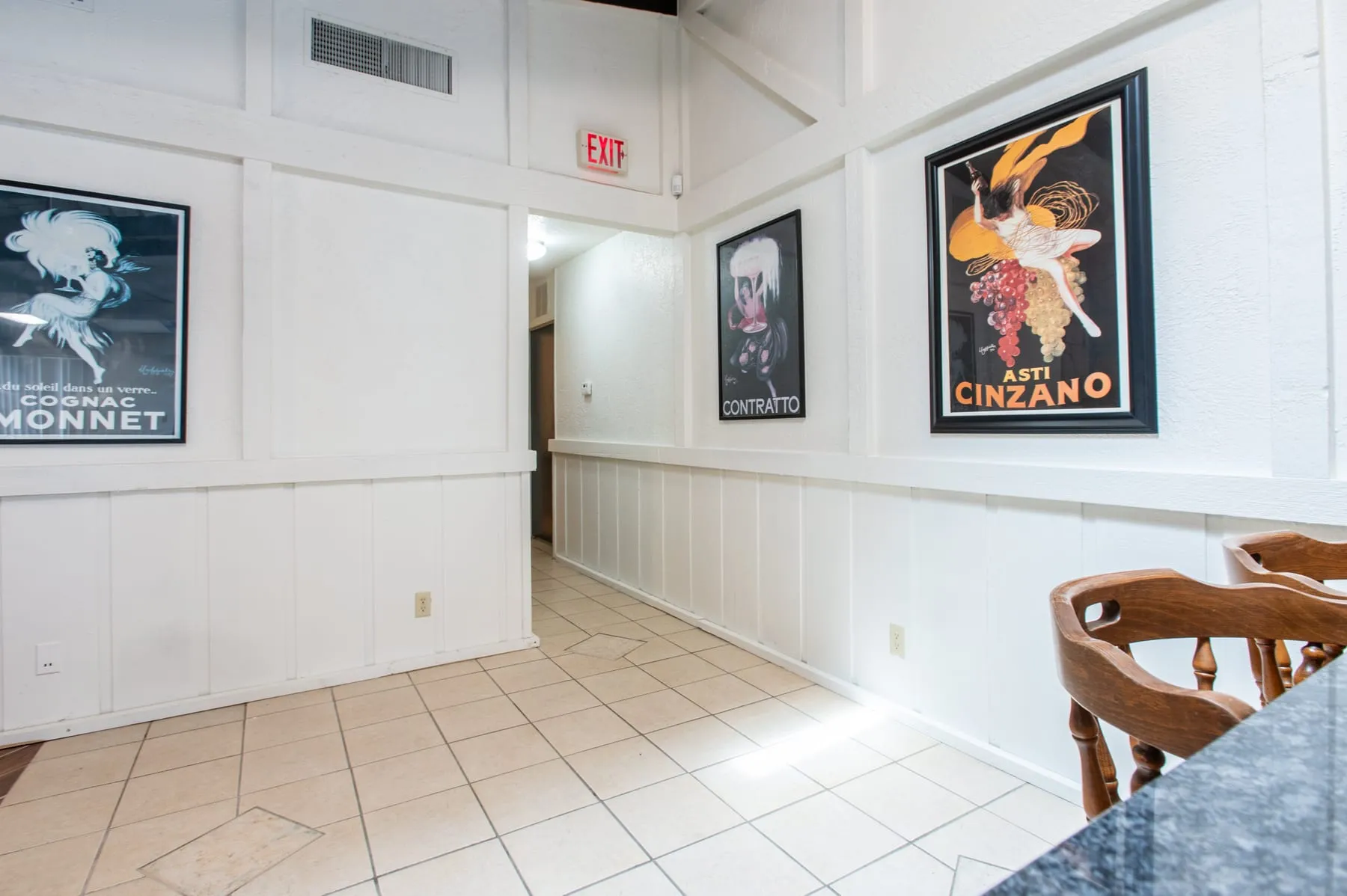 Clubhouse room set with tables and framed prints along the wall.