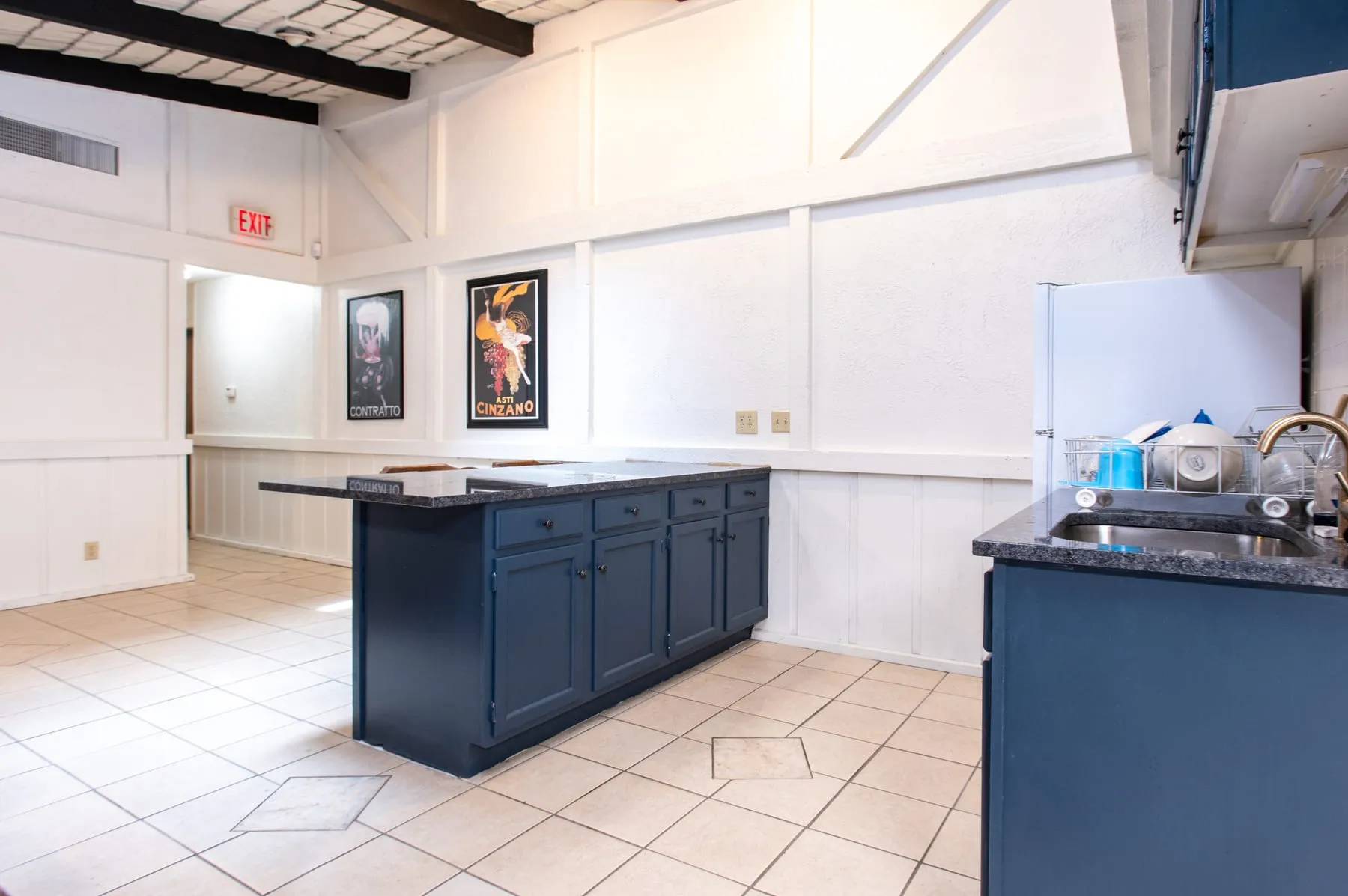 Clubhouse kitchen with a tiled floor and blue cabinetry.