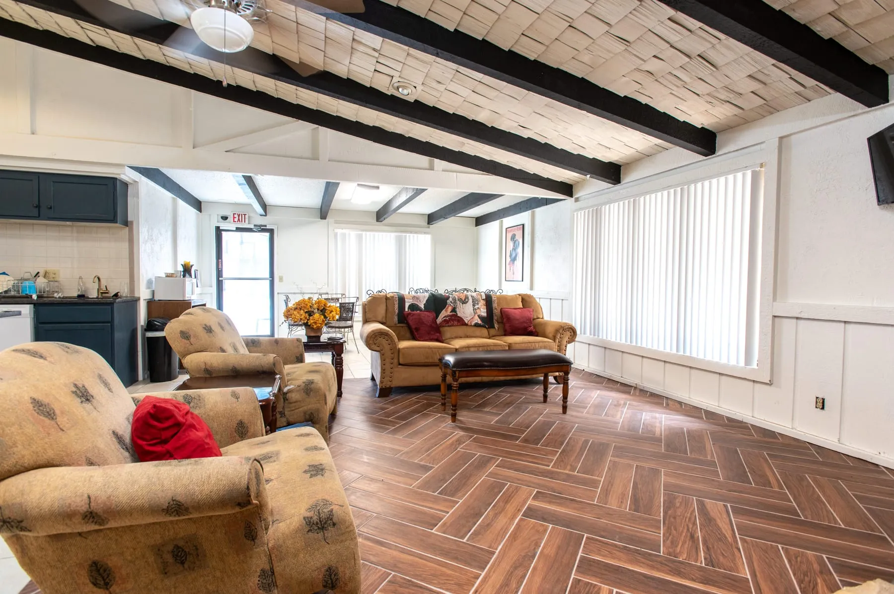 Clubhouse lounge at Stoneybrook with exposed beams, a cedar shake ceiling and herringbone tile flooring.