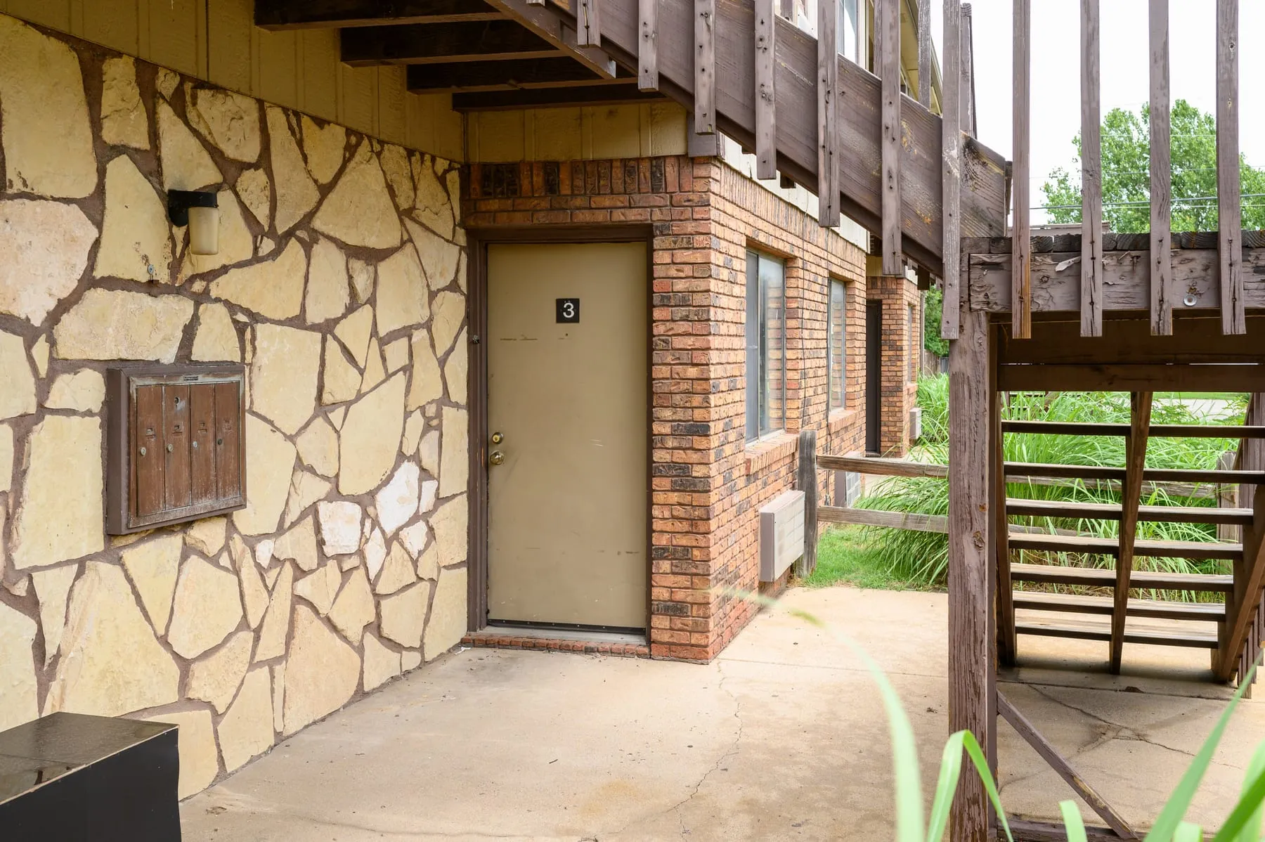 Covered breezeway at Stoneybrook with stone masonry and unit entrances.