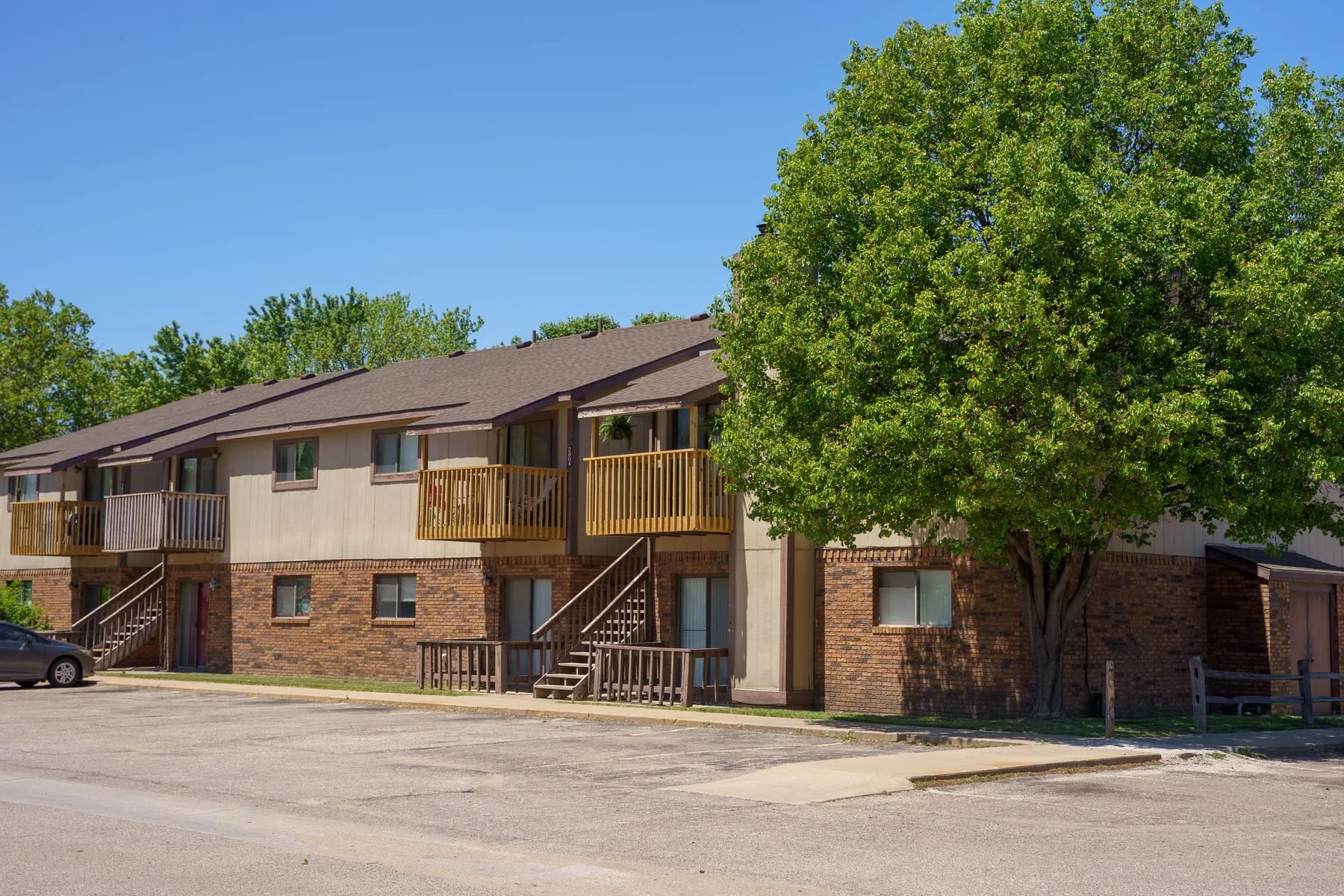 Stoneybrook apartment building and surface parking on a clear day.