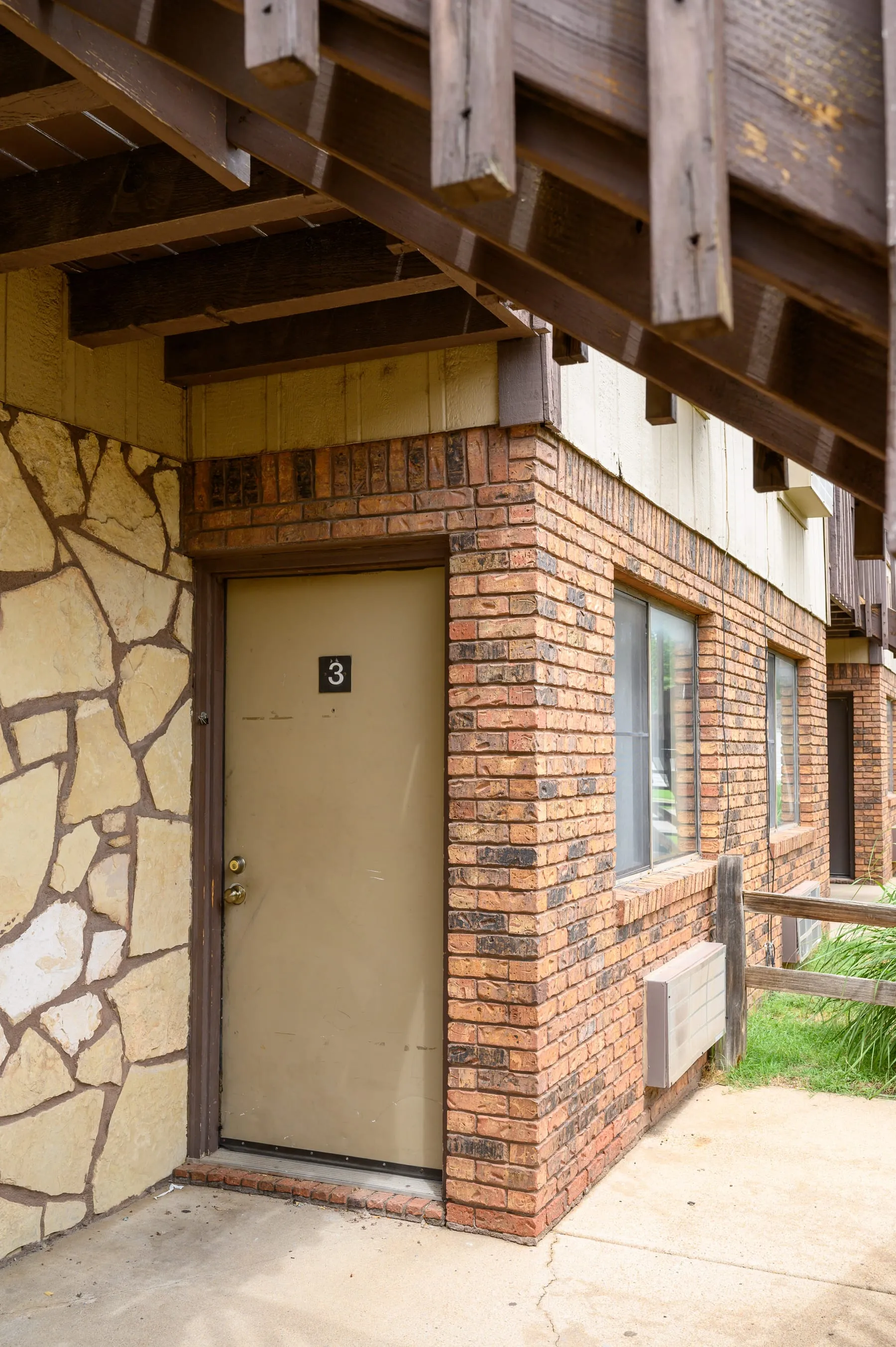 Ground-floor apartment entrance framed by stone and brick.