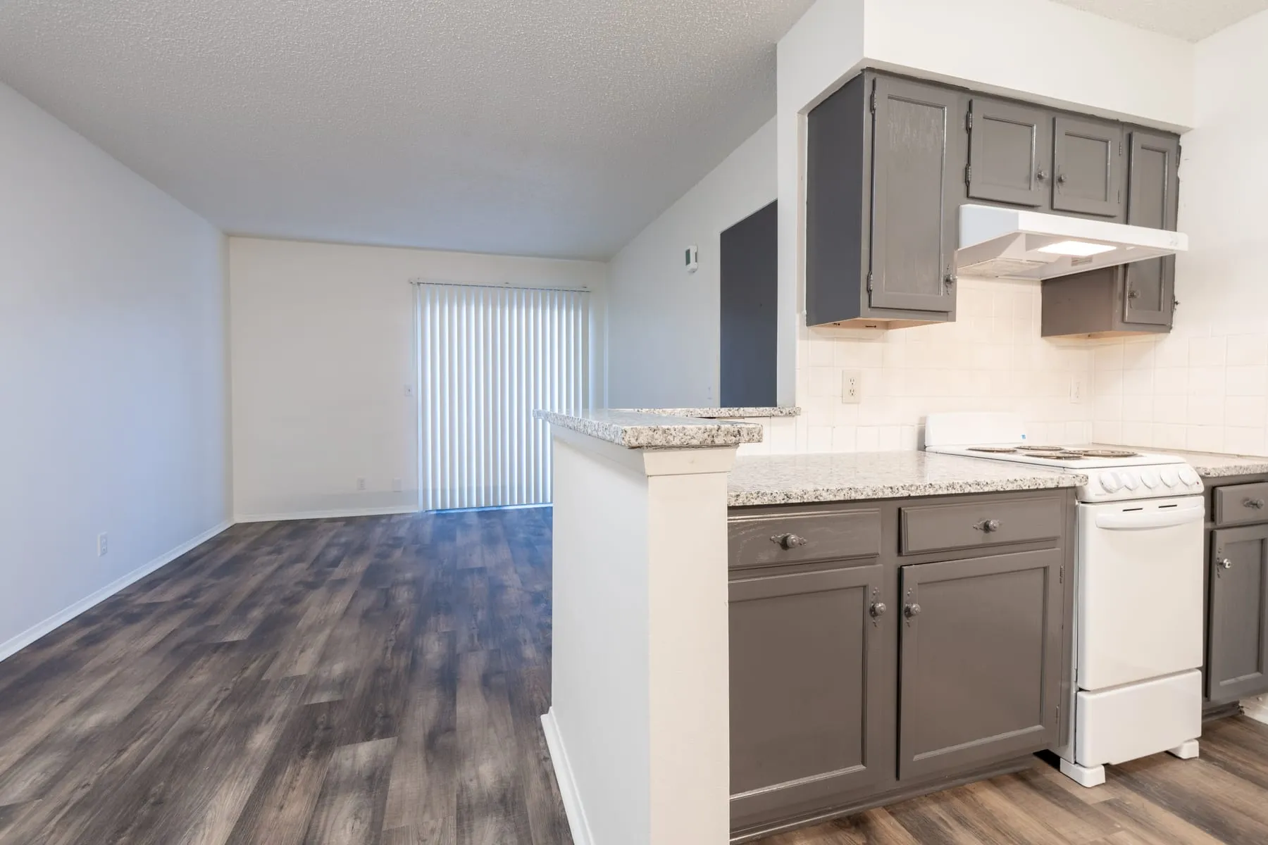 Graphite cabinetry, granite counters and a range in a renovated one bedroom kitchen.