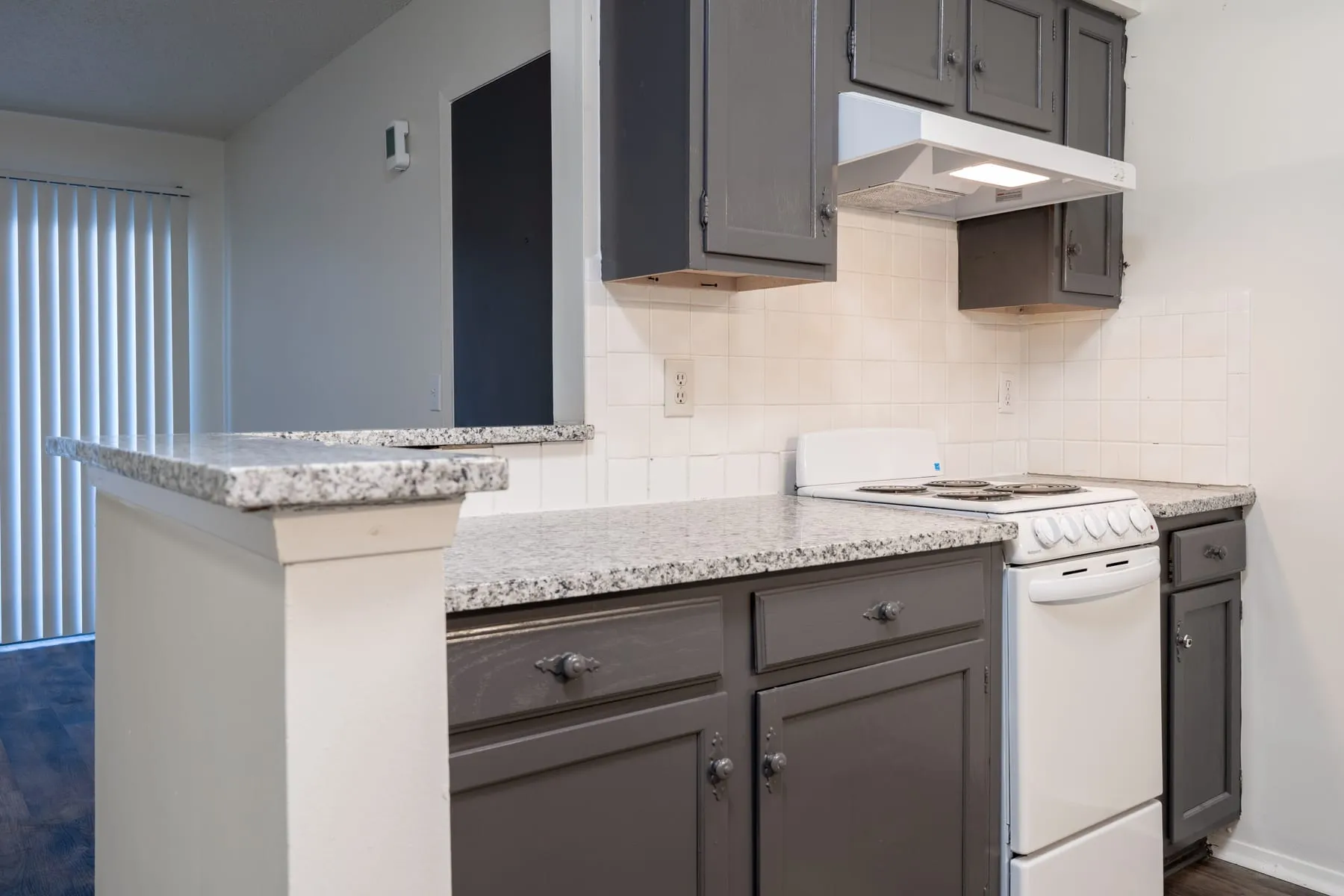 One bedroom kitchen peninsula in granite with graphite cabinets below.