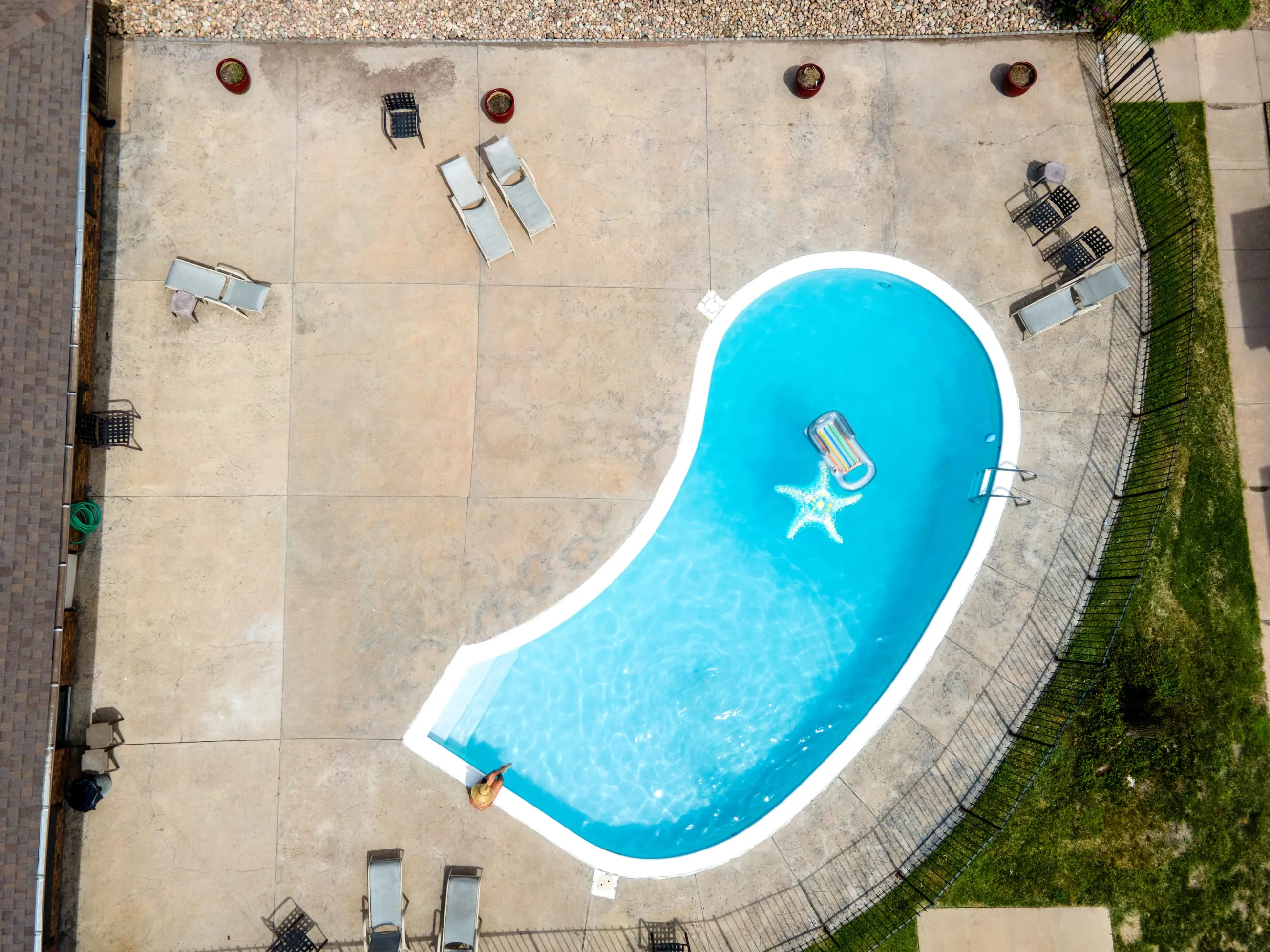 Aerial view of the outdoor pool at Stoneybrook, with a curved deck and lounge seating.