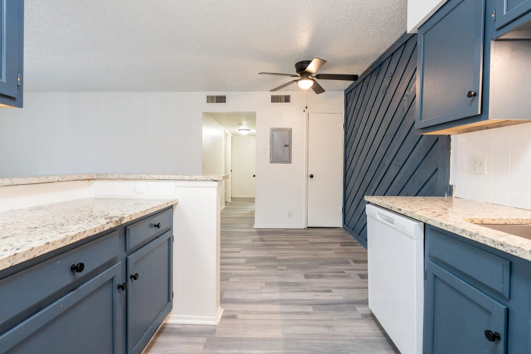 Stained diagonal plank accent wall behind the kitchen in a renovated two bedroom home.