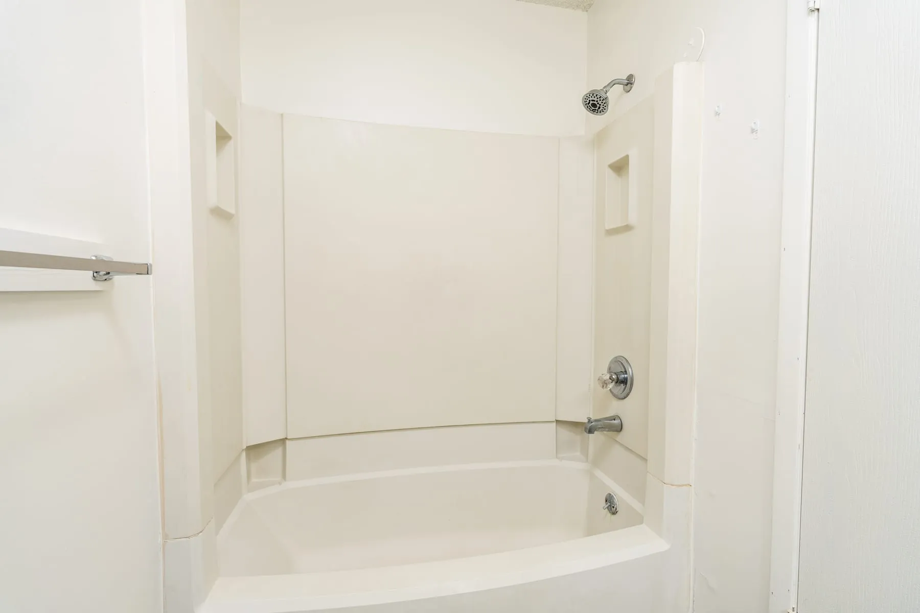 Tub and shower surround in a renovated two bedroom bathroom.