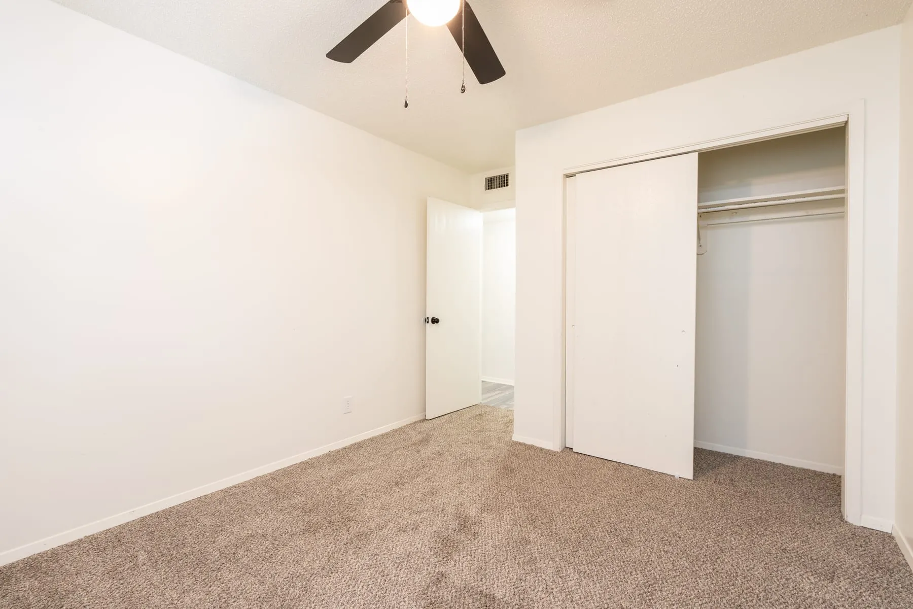Two bedroom sleeping area with a wide closet and carpet.