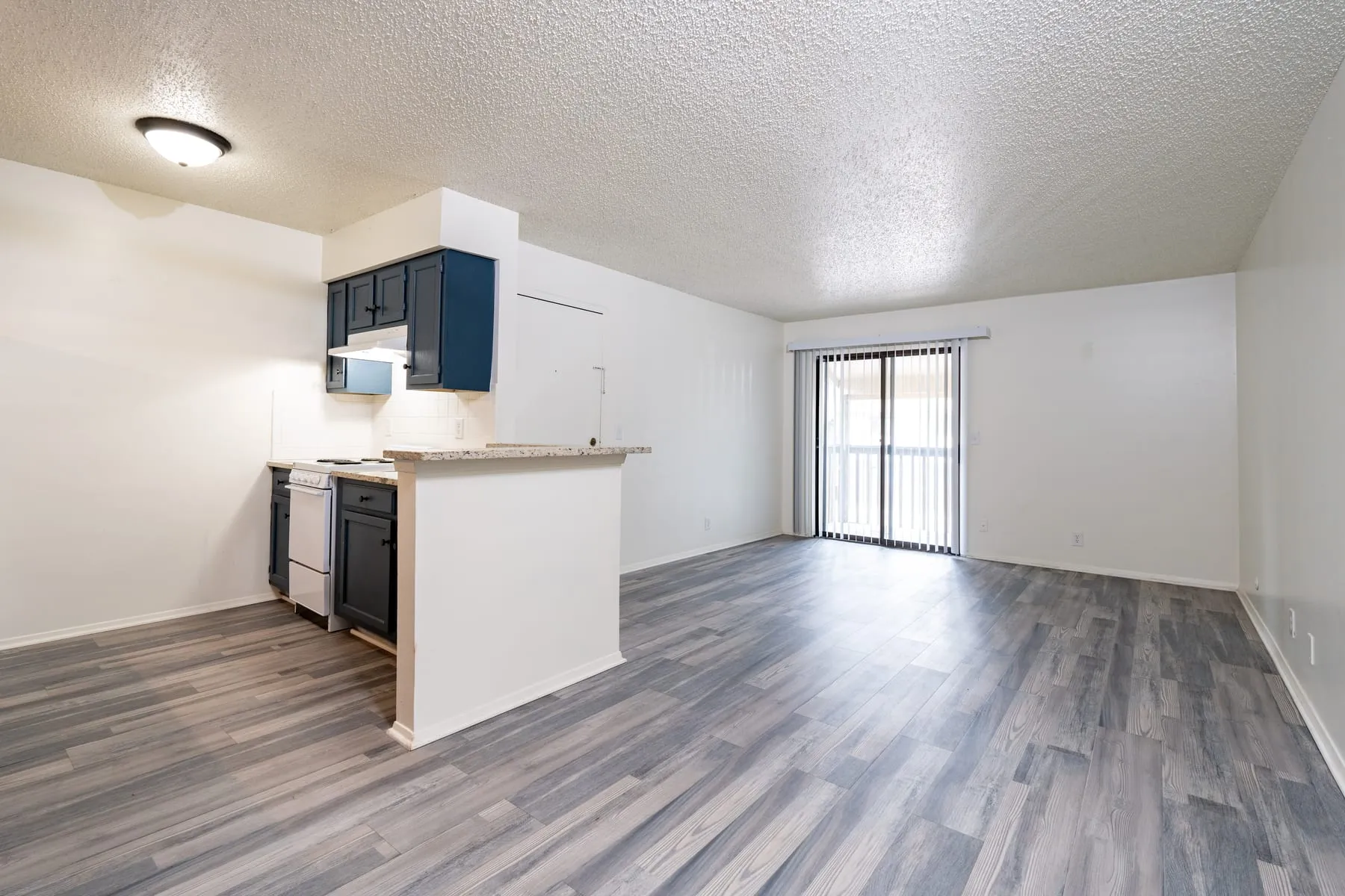 Open two bedroom living and dining space with the kitchen peninsula beyond.