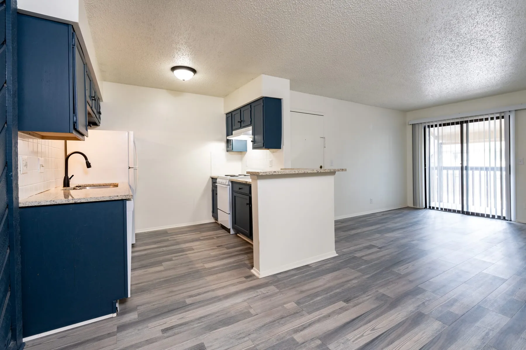 Two bedroom living area with plank flooring running to the balcony doors.